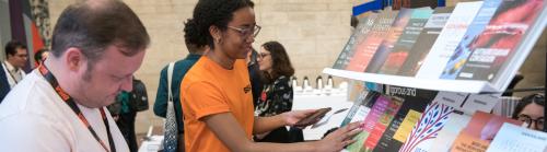 Two people browsing a conference exhibition stand