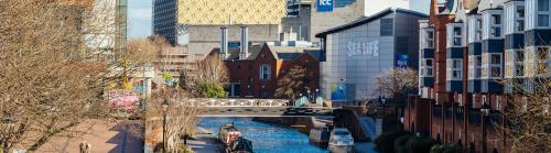 A landscape of a Birmingham canal with the Sealife Centre and Library in the distance