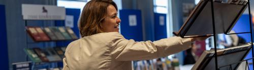 A woman in a cream suit looking at exhibitor stands at the BISA 2024 conference